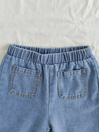 طقم ملابس بناتي ربيعي/خريفي مكون من ثلاث قطع: جاكيت جينز أزرق فاتح بأكمام طويلة، تيشيرت أبيض بأكمام قصيرة، وبنطال جينز.