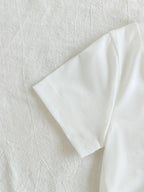 طقم ملابس بناتي ربيعي/خريفي مكون من ثلاث قطع: جاكيت جينز أزرق فاتح بأكمام طويلة، تيشيرت أبيض بأكمام قصيرة، وبنطال جينز.