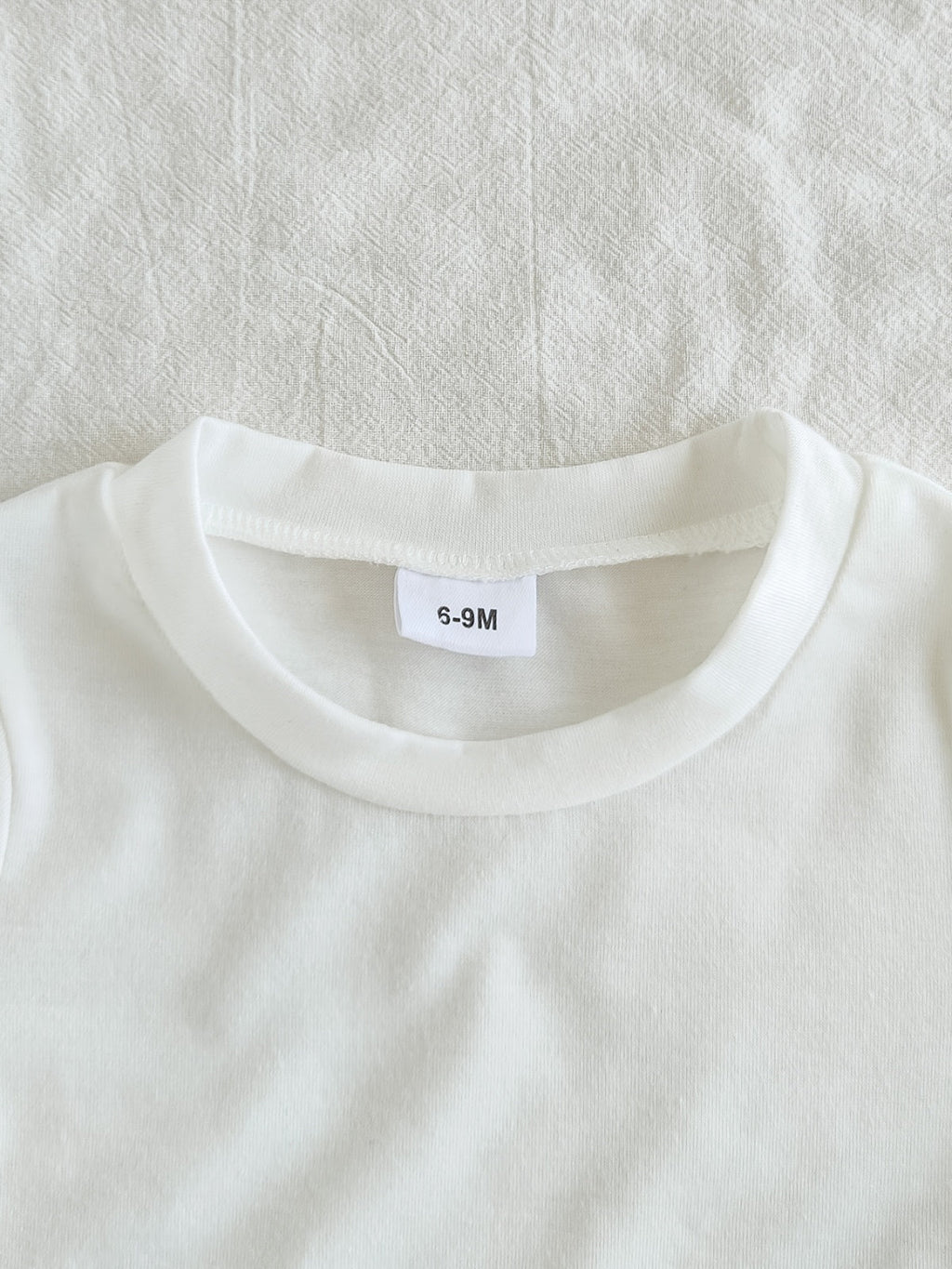 طقم ملابس بناتي ربيعي/خريفي مكون من ثلاث قطع: جاكيت جينز أزرق فاتح بأكمام طويلة، تيشيرت أبيض بأكمام قصيرة، وبنطال جينز.