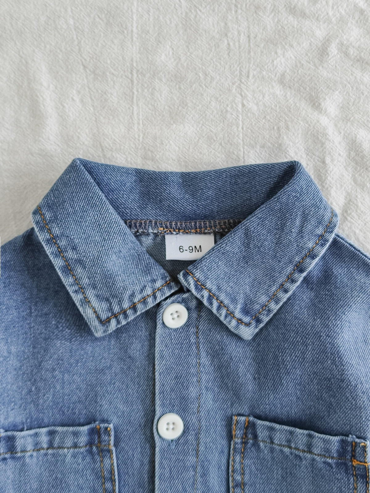 طقم ملابس بناتي ربيعي/خريفي مكون من ثلاث قطع: جاكيت جينز أزرق فاتح بأكمام طويلة، تيشيرت أبيض بأكمام قصيرة، وبنطال جينز.