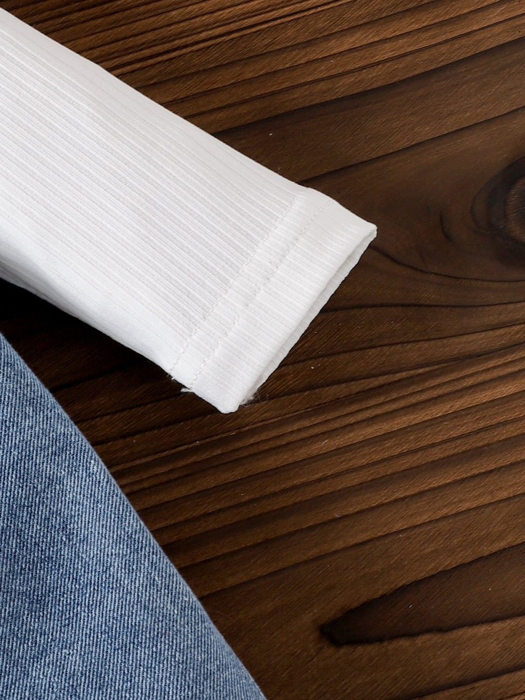 طقم مكون من قطعتين: تيشيرت بأكمام طويلة وبنطال جينز مزين بجيب على شكل قلب وفيونكة.