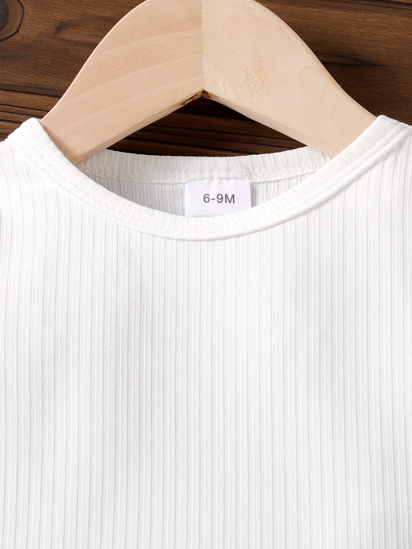 طقم مكون من قطعتين: تيشيرت بأكمام طويلة وبنطال جينز مزين بجيب على شكل قلب وفيونكة.