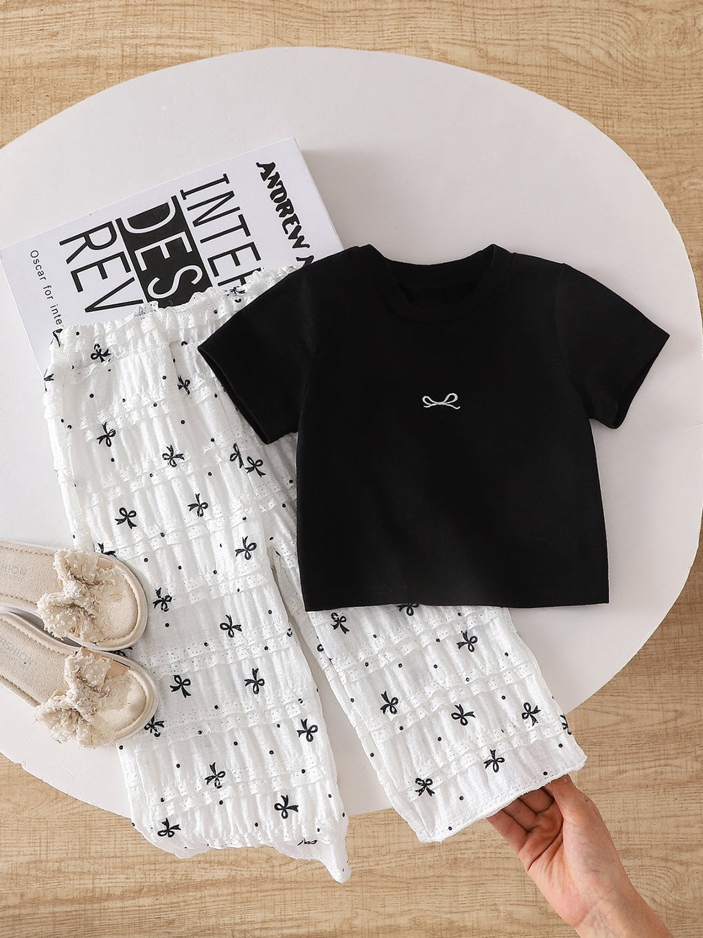 طقم صيفي مكون من قطعتين للبنات الصغيرات: تيشيرت أسود بأكمام قصيرة وبنطال أبيض مزين بفيونكة