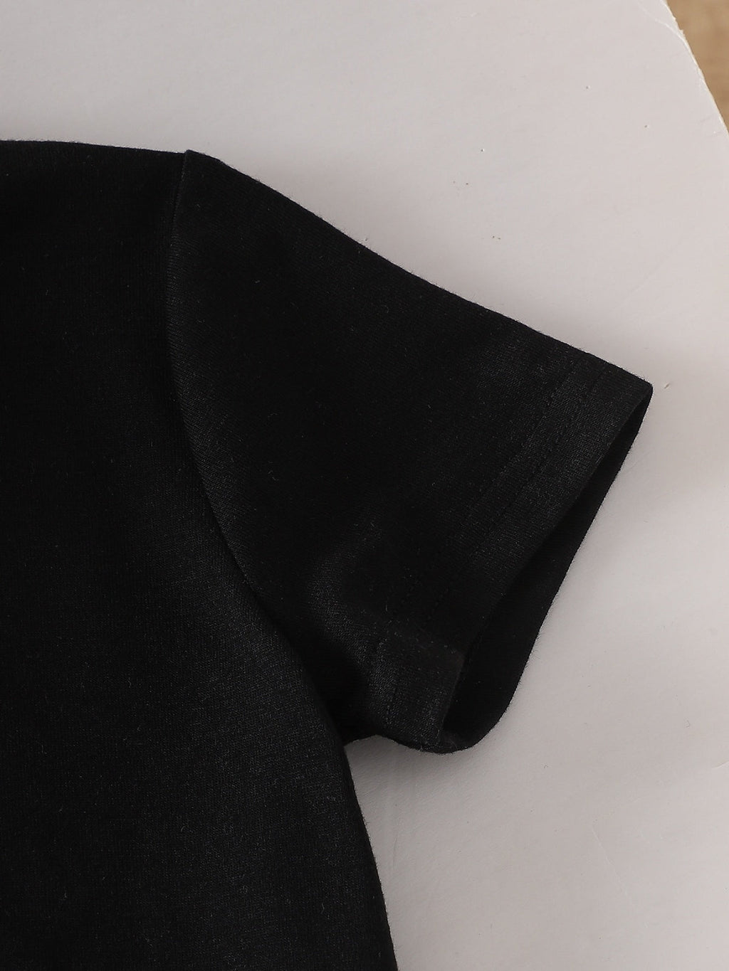 طقم صيفي مكون من قطعتين للبنات الصغيرات: تيشيرت أسود بأكمام قصيرة وبنطال أبيض مزين بفيونكة