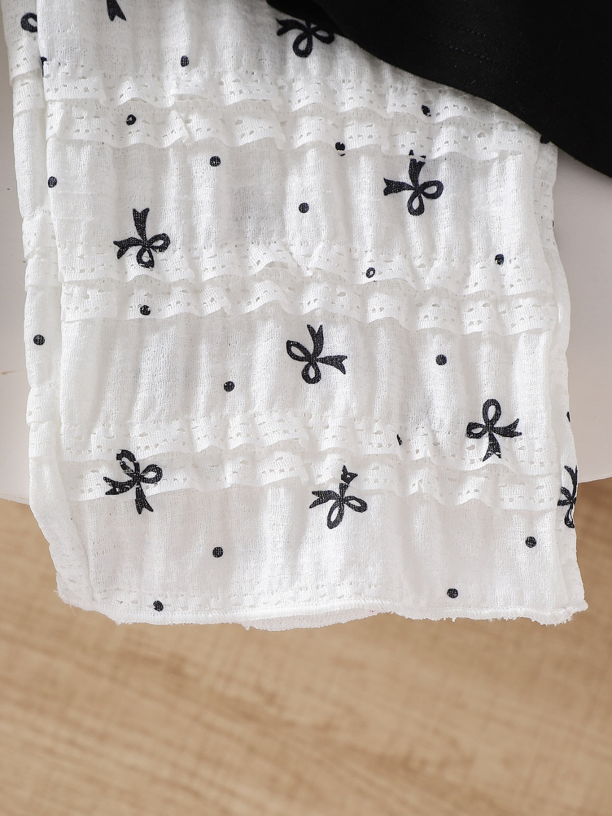 طقم صيفي مكون من قطعتين للبنات الصغيرات: تيشيرت أسود بأكمام قصيرة وبنطال أبيض مزين بفيونكة