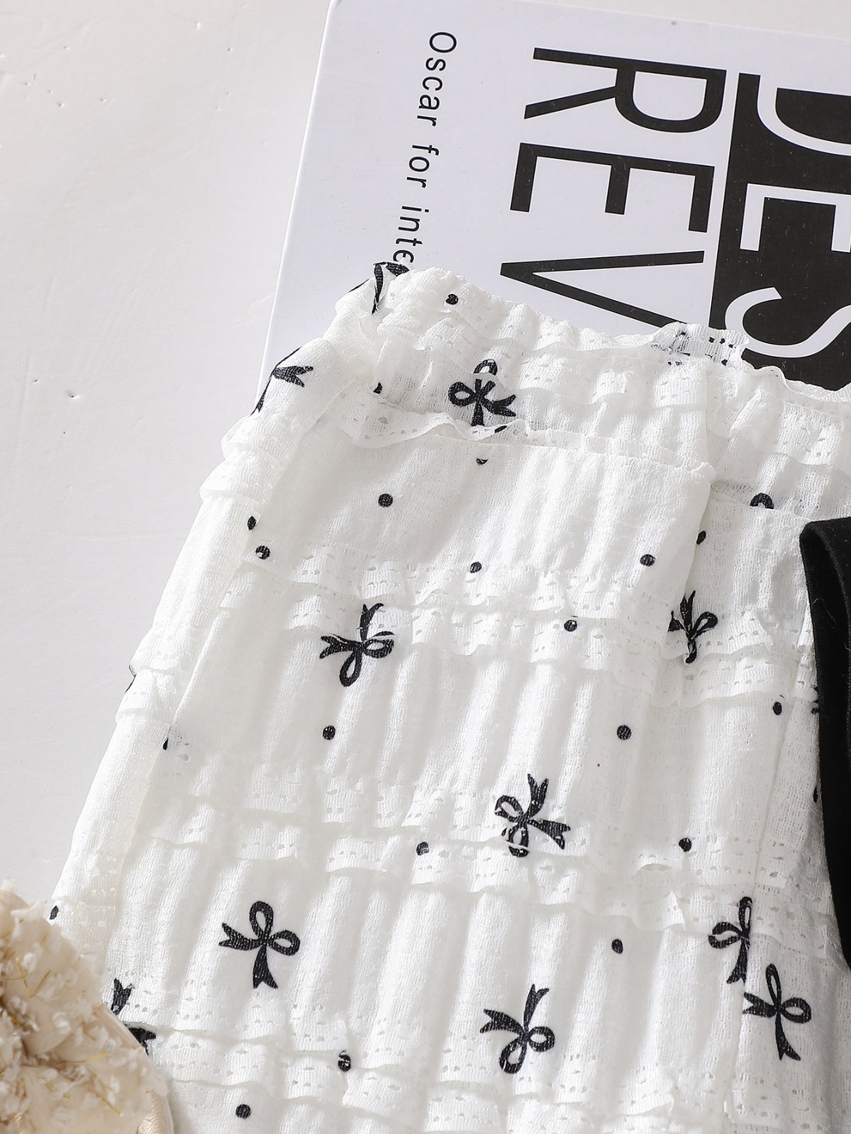 طقم صيفي مكون من قطعتين للبنات الصغيرات: تيشيرت أسود بأكمام قصيرة وبنطال أبيض مزين بفيونكة