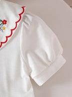 طقم صيفي مكون من قطعتين للبنات الصغيرات: بلوزة قصيرة الأكمام مطرزة بياقة بيتر بان وتنورة مطوية مزينة بالزهور