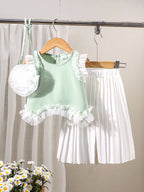 طقم مكون من ثلاث قطع للبنات الصغيرات: بلوزة خضراء بدون أكمام بتصميم غير منتظم وتنورة طويلة مطوية مع حقيبة واحدة