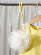 طقم مكون من ثلاث قطع للبنات الصغيرات: بلوزة صفراء بدون أكمام بتصميم غير منتظم وتنورة طويلة مطوية مع حقيبة واحدة