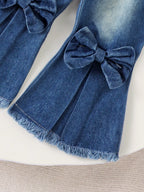 طقم مكون من قطعتين للبنات الصغيرات، مناسب لفصلي الربيع والخريف، يتألف من سويت شيرت بأكمام طويلة مزين بطبعة فيونكة وبنطال جينز واسع الساقين.