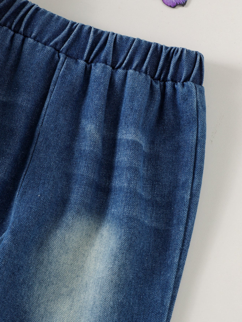 طقم مكون من قطعتين للبنات الصغيرات، مناسب لفصلي الربيع والخريف، يتألف من سويت شيرت بأكمام طويلة مزين بطبعة فيونكة وبنطال جينز واسع الساقين.